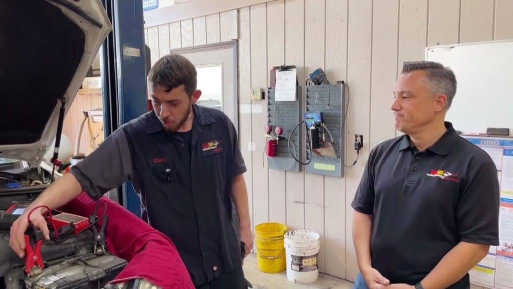two employees inspecting car