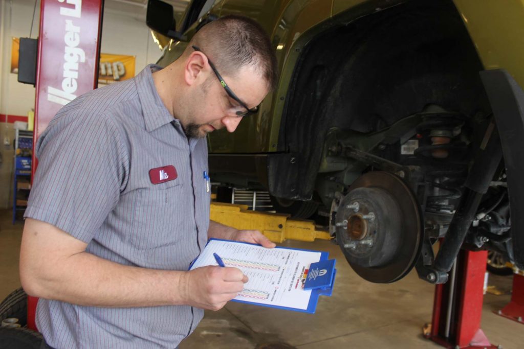 A technician inspecting the thickness of the brakes